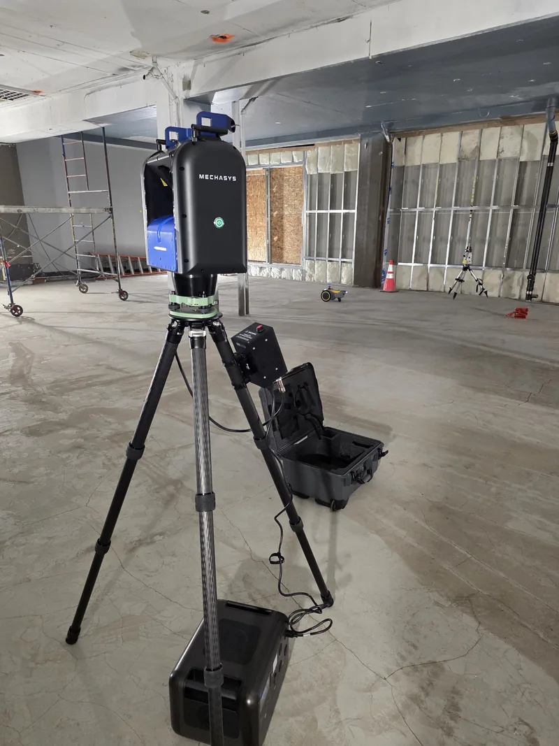 XR Projector set up on an open concrete floor beside its wheeled hard case and portable battery